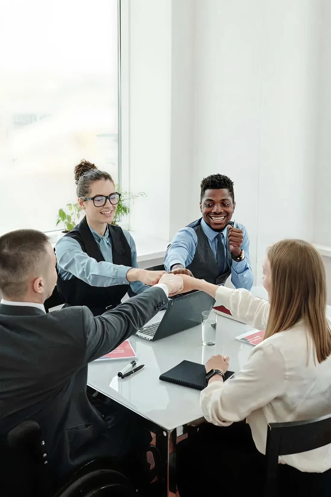 Colleagues shaking hands across a table during a corporate travel meeting