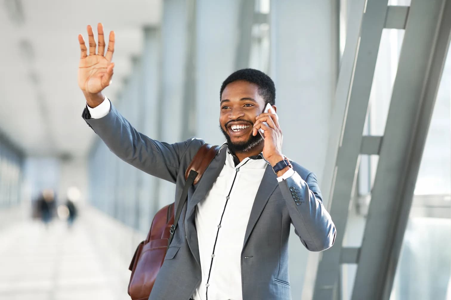 A traveler waving as he arrives outside the departures terminal