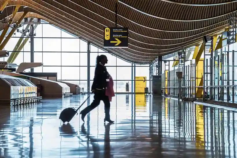 A concierge greeting an arriving traveler inside an airport terminal