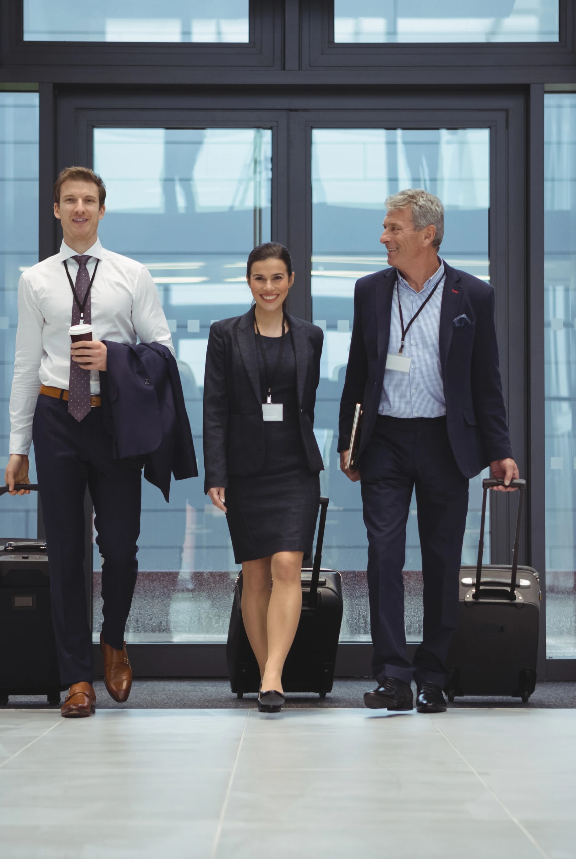 Business travelers walking through an airport terminal with luggage