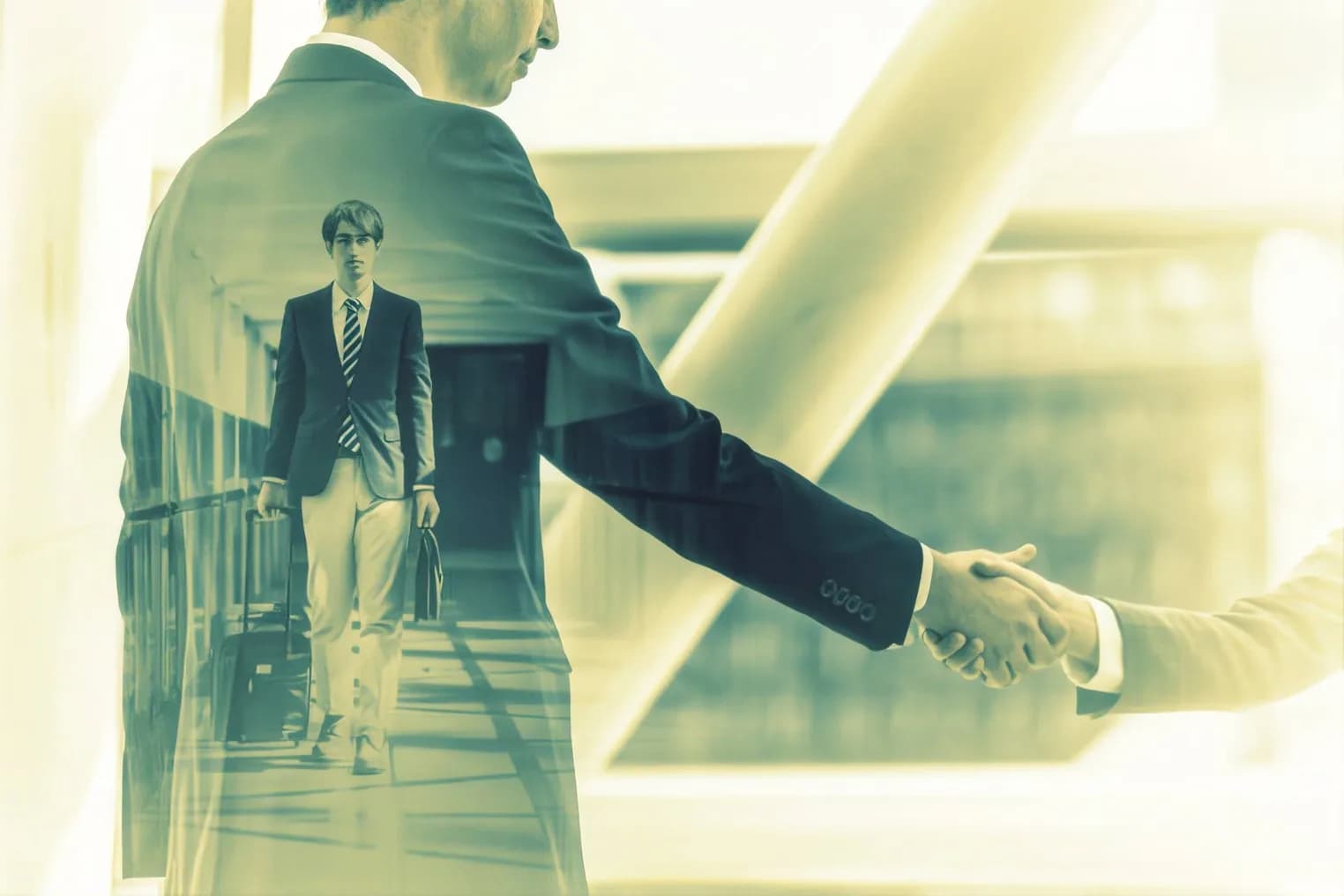 A greeter shaking hands with an arriving traveler in an airport terminal