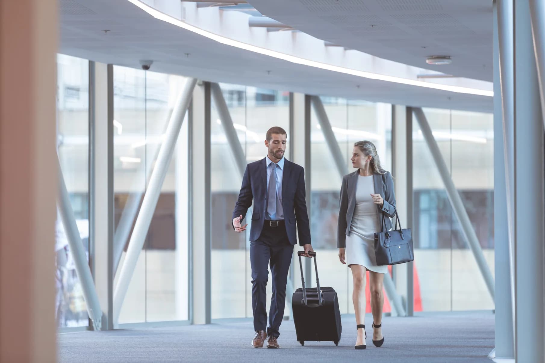 Business travelers walking together through a bright terminal corridor