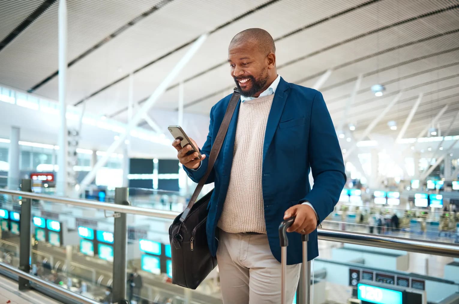 A traveler checking flight details on a phone in the terminal